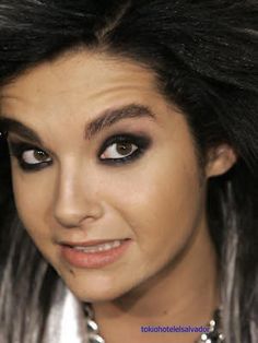 a close up of a person with long hair and black eyeliners on her face