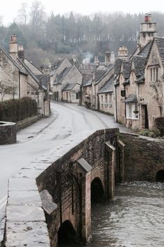 a flooded street with houses on either side and water running down the road in front of it