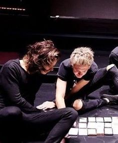 three young men sitting on top of a keyboard