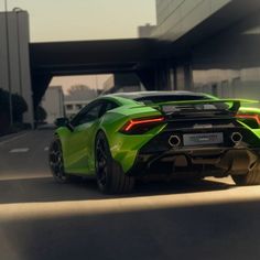 a green sports car driving down the road