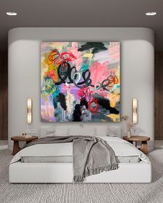 a large painting on the wall above a bed in a room with white walls and carpet