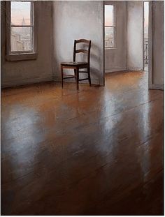 an empty chair sits in the corner of a room with large windows and wooden floors