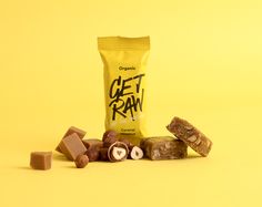 a bag of get raw chocolate next to some pieces of it on a yellow background