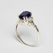 an oval shaped ring with a blue stone in the center