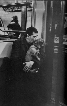 a man sitting on a bus with his dog