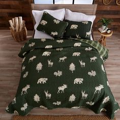 the bed is made with green and white animals on it