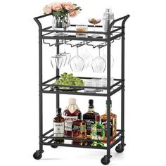 a metal bar cart with wine glasses and bottles on the top, two shelves filled with liquor