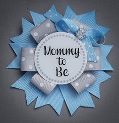 a blue and white bow with the words mommy to be on it's center