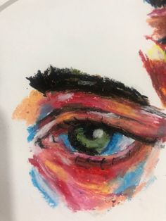 an eye painted with multicolored paint on a white surface next to a drawing of a man's face