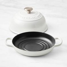 two white pots and one black pan