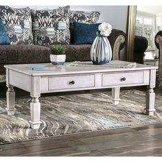 a white coffee table sitting on top of a rug in front of a couch and chair