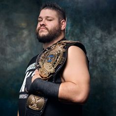 a man with a beard wearing a wrestling ring and holding his arms crossed in front of him