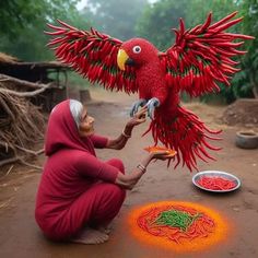 a woman kneeling down next to a red bird on top of a table covered in food