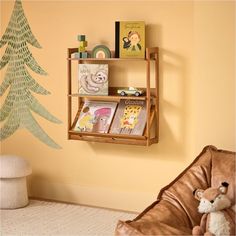 a book shelf with books on it and a stuffed animal next to it in front of a yellow wall