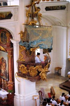 an overhead view of a church with people sitting at the alter and paintings on the walls