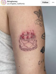 a woman's arm with a tattoo on it that has a cake in the middle