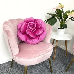 two pink chairs and a white table with flowers on it