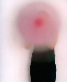 a blurry image of a person holding a red object