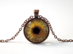 an eyeball is shown in the center of a chain pendant on a white background