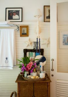 a table with flowers and candles on it in front of a door that leads to the bathroom