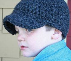 a young boy wearing a crocheted blue hat