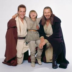 two men and a young boy are posing for a photo in star wars costumes, one is holding his arm around the other's shoulder