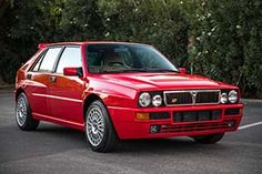 a red car is parked in a parking lot