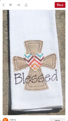 a white towel with a cross on it that says, bleeded in brown and blue