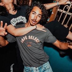 two young men are hugging each other in the middle of a crowd at a party