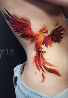 a woman's stomach with a red and yellow bird tattoo on her side belly