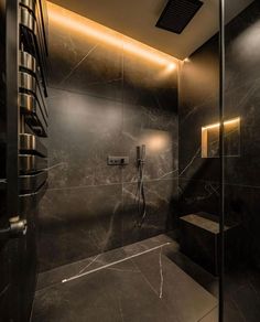 a bathroom with black marble walls and flooring is shown in this modern style shower