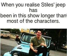 a man sitting on the hood of a blue jeep in front of a sign that reads, when you raise stils'jeep has been in this show longer than most of the characters