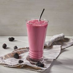 a pink smoothie with blackberries on the side