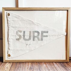 a wooden frame with a surf sign hanging from it's side on a wood floor