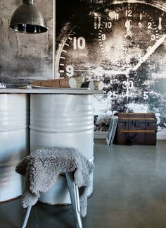 a room with a large clock on the wall and a stool in front of it