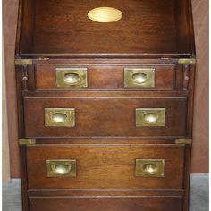 an old wooden file cabinet with brass handles