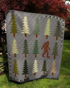 a bigfoot quilt on the grass in front of some trees