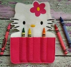 a hello kitty pencil holder with crayons in it