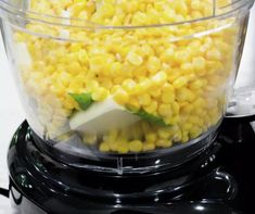 a blender filled with corn on top of a counter