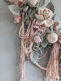 a crocheted wreath with flowers hanging on the wall