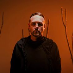 a man standing in front of some branches