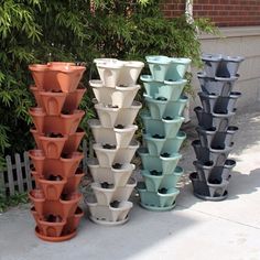 several different colored plastic flower pots on the sidewalk