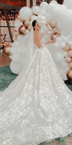 a woman in a wedding dress standing next to balloons