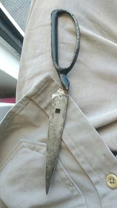 an old pair of scissors is stuck in the pocket of a man's pants