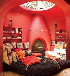 a living room filled with furniture and a fire place in the middle of it's walls