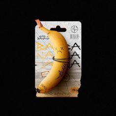 a yellow banana with writing on it sitting in front of a black background that has graffiti written all over it