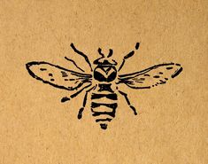 a drawing of a bee on a piece of brown paper with black ink in it