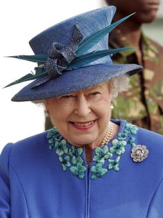 an older woman wearing a blue outfit and hat