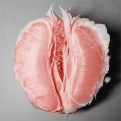 the inside of a peeled pink fruit on a gray surface with white trim around it