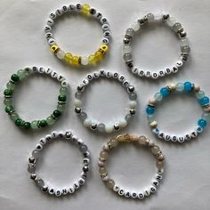 six bracelets with beads and letters on them